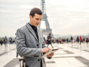uomo d'affari consulta il tablet sullo sfondo della tour eiffel