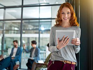 ragazza sorridente con tablet in mano in ufficio