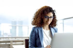 giovane ragazza con occhiali davanti a laptop